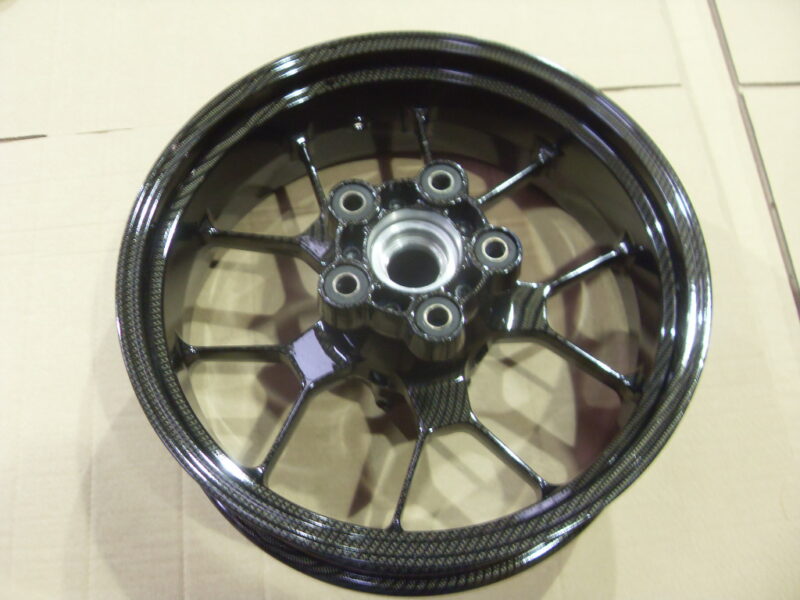 Motorbike alloy wheels coated in carbon fibre painted black