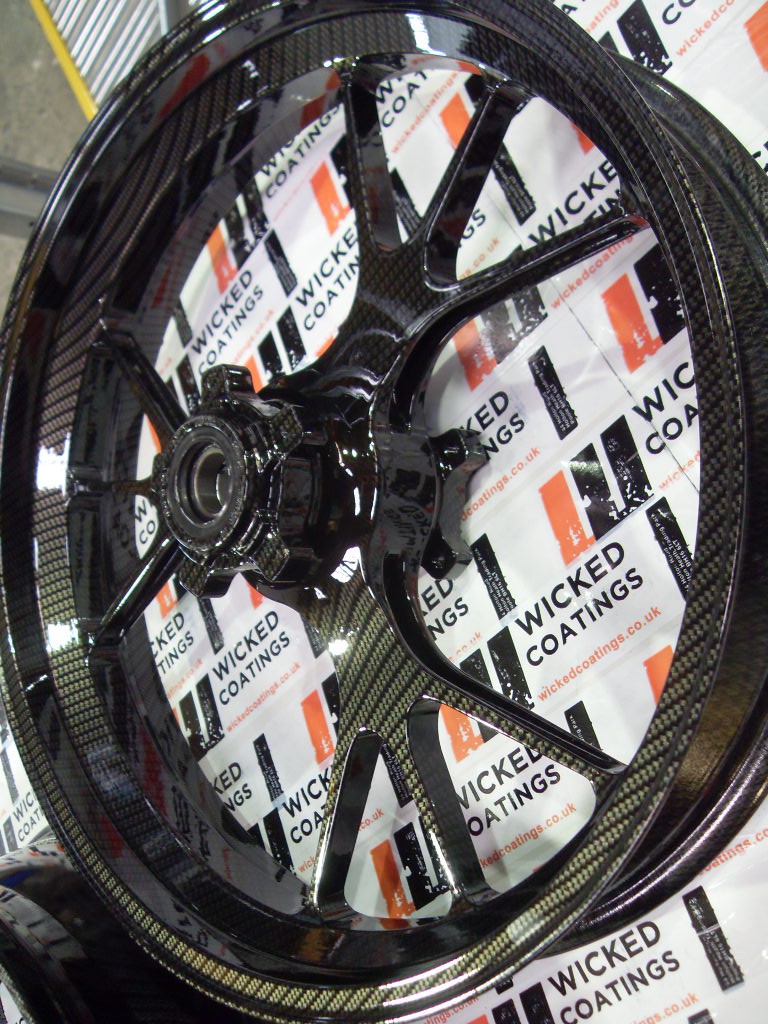 Motorbike alloy wheels coated in carbon fibre painted black