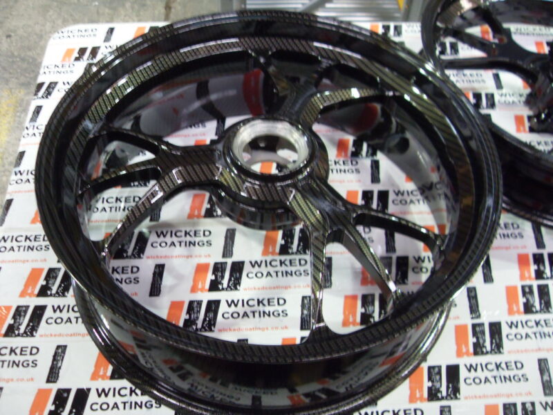 Motorbike alloy wheels coated in carbon fibre painted black