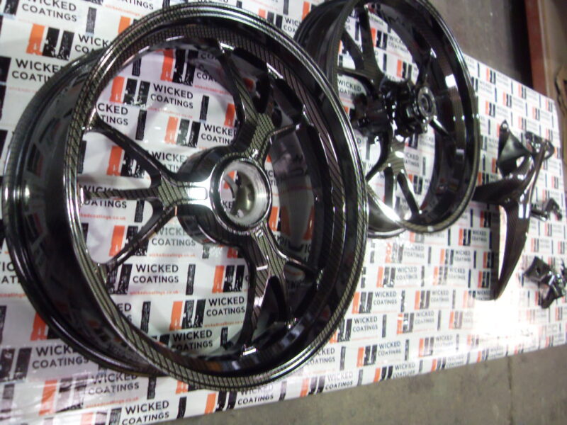 Motorbike alloy wheels coated in carbon fibre painted black