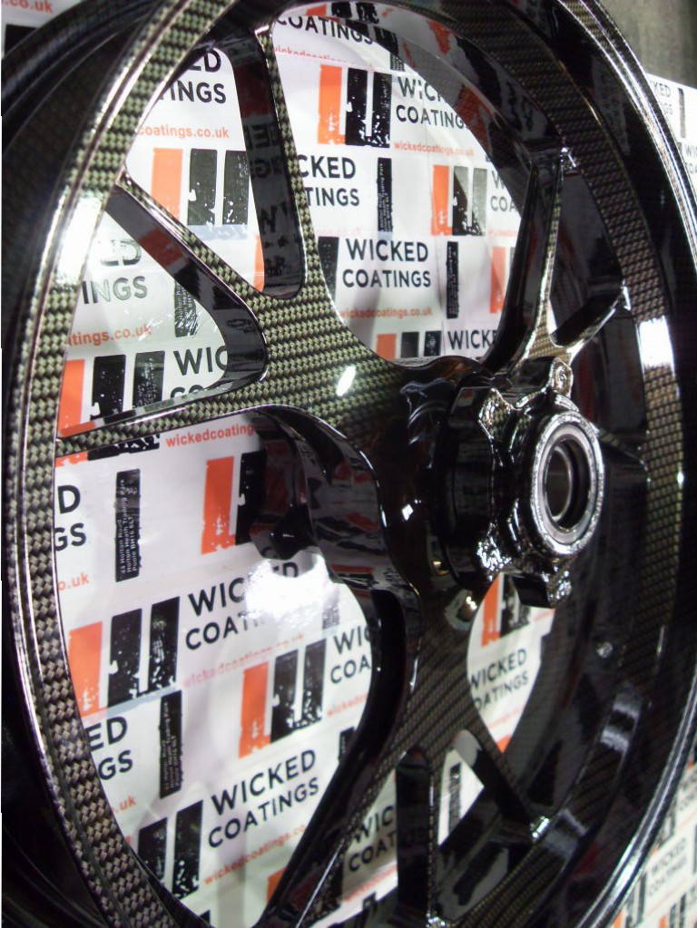 Motorbike alloy wheels coated in carbon fibre painted black