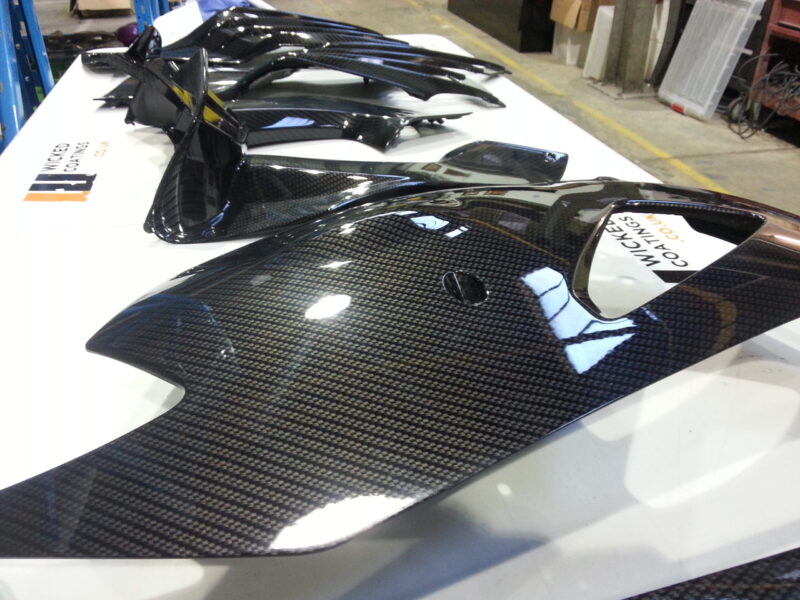 Motorbike parts coated in carbon fibre hydrographic film painted black