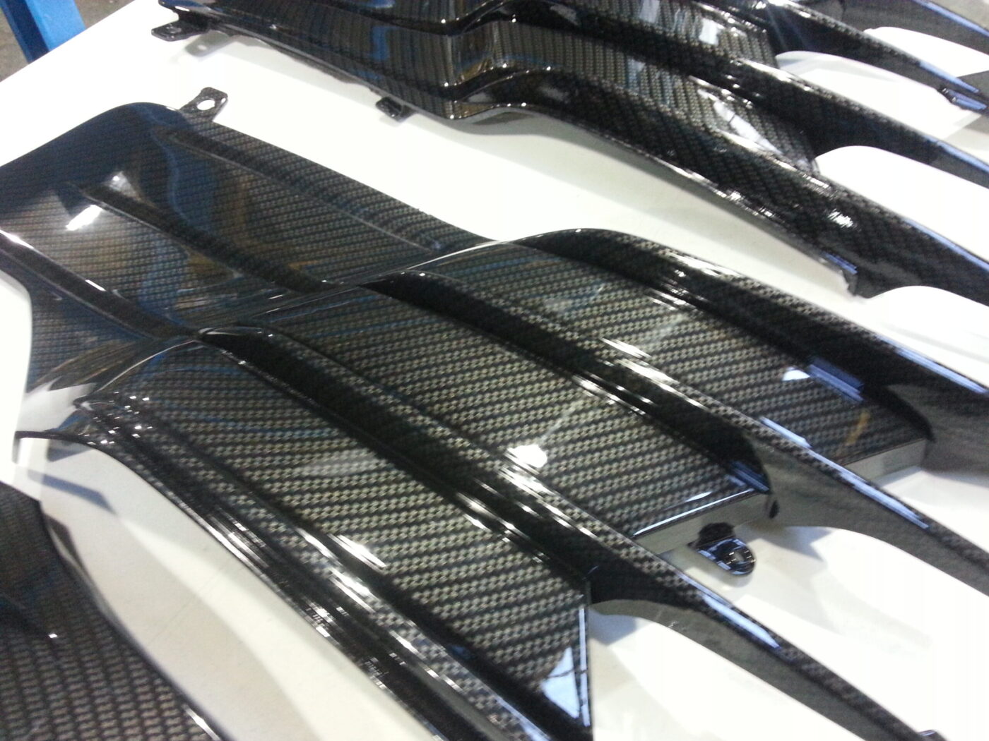 Motorbike parts coated in carbon fibre hydrographic film painted black
