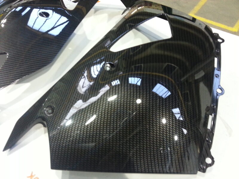 Motorbike parts coated in carbon fibre hydrographic film painted black