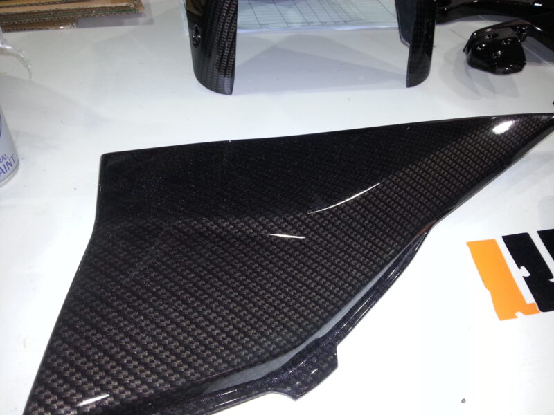 Motorbike parts coated in carbon fibre hydrographic film painted black
