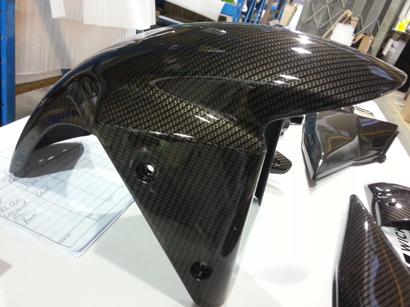 Motorbike parts coated in carbon fibre hydrographic film painted black