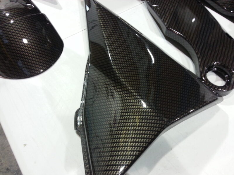 Motorbike parts coated in carbon fibre hydrographic film painted black