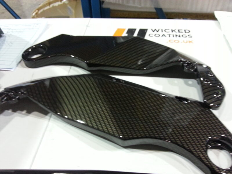 Motorbike parts coated in carbon fibre hydrographic film painted black