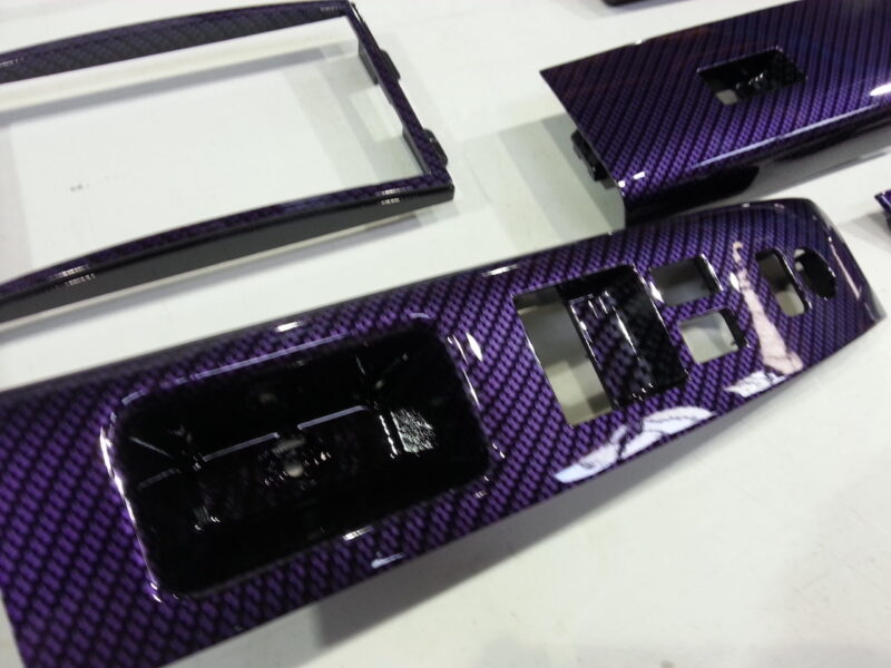 Car dashboard elements coated in carbon fibre hydrographic film painted purple
