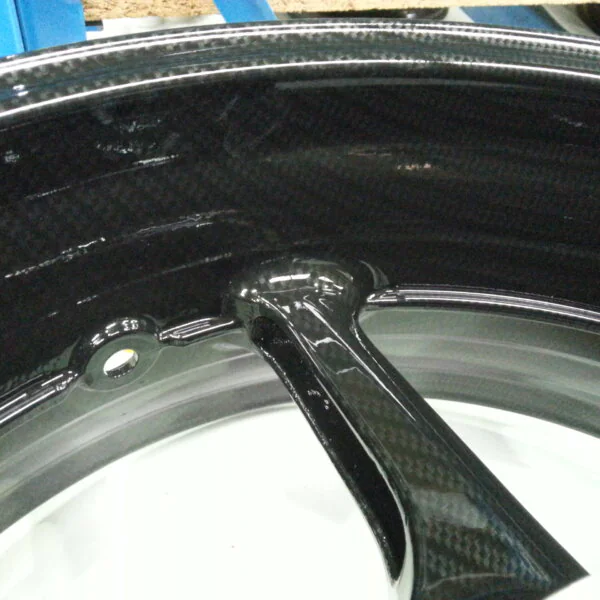 Motorbike alloy wheels coated in carbon fibre hydrographic film painted black