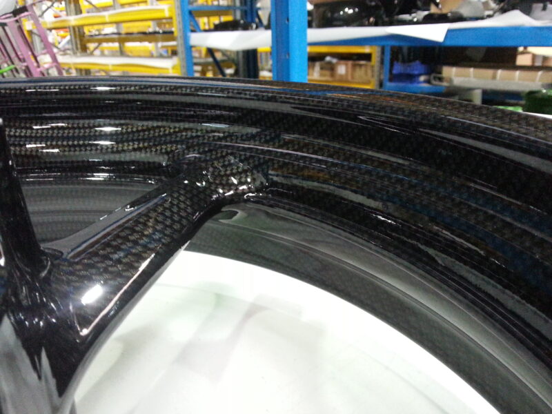 Motorbike alloy wheels coated in carbon fibre hydrographic film painted black