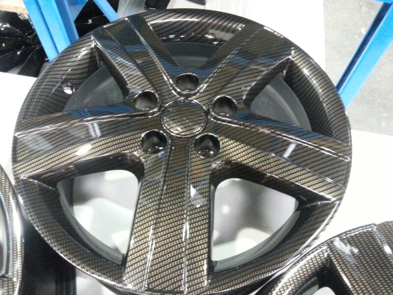 Car alloy wheels coated in carbon fibre hydrographic film painted black
