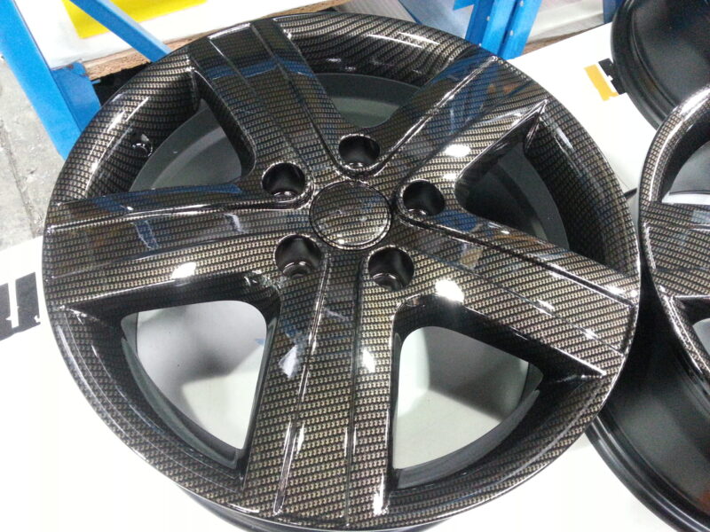 Car alloy wheels coated in carbon fibre hydrographic film painted black