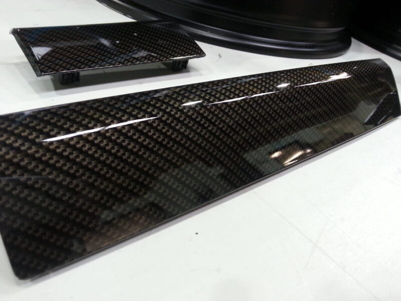 Car alloy wheels coated in carbon fibre hydrographic film painted black