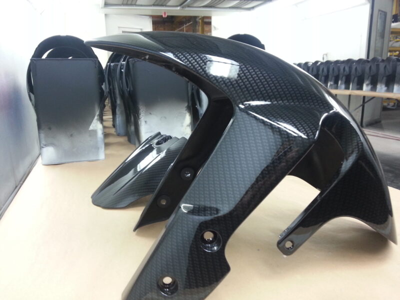 Motorbike parts coated in carbon fibre hydrographic film painted black