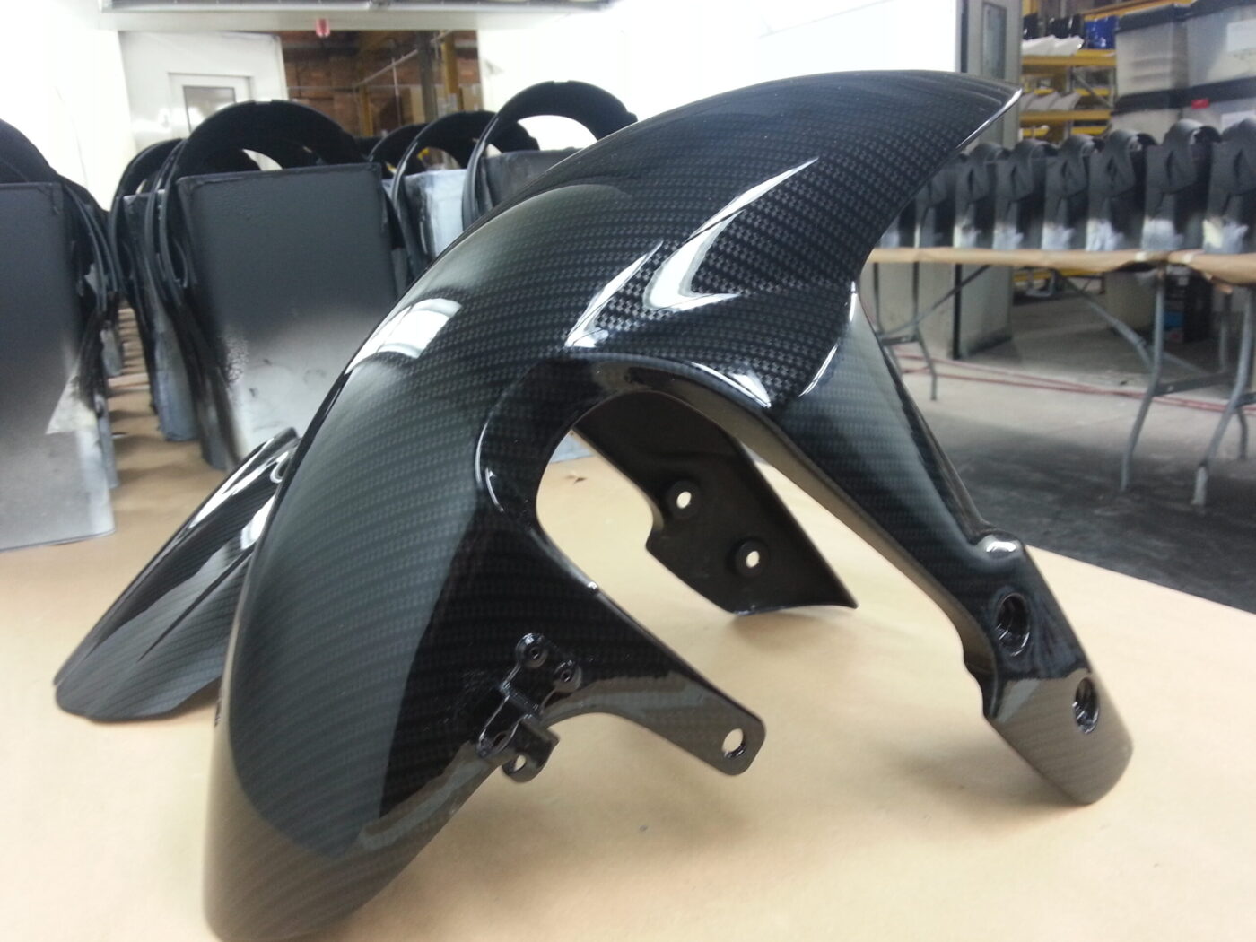 Motorbike parts coated in carbon fibre hydrographic film painted black