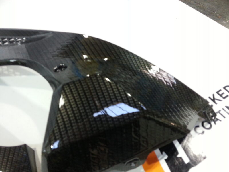 Motorbike parts coated in carbon fibre hydrographic film painted black