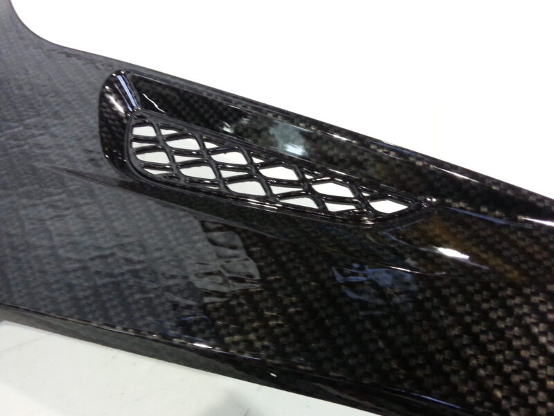 Motorbike parts coated in carbon fibre hydrographic film painted black