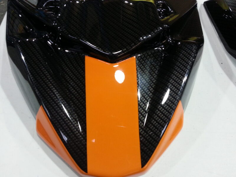 Motorbike parts coated in carbon fibre hydrographic film painted black and orange