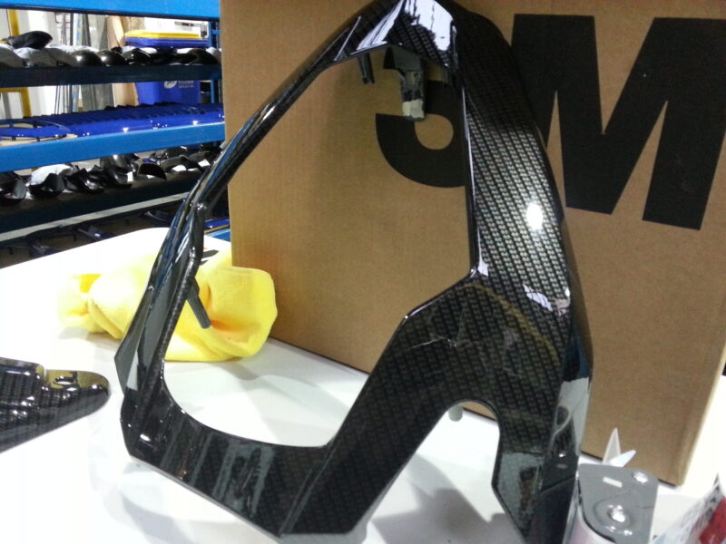 Motorbike parts coated in carbon fibre hydrographic film painted black and orange
