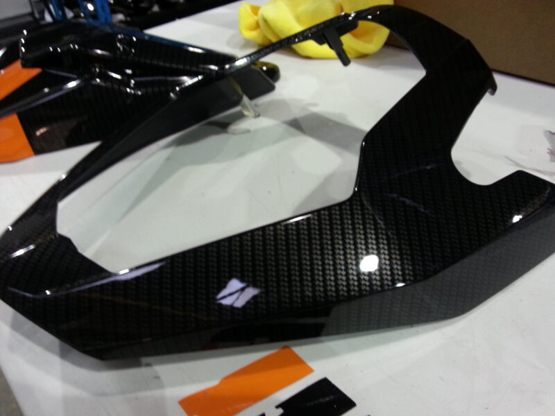 Motorbike parts coated in carbon fibre hydrographic film painted black and orange