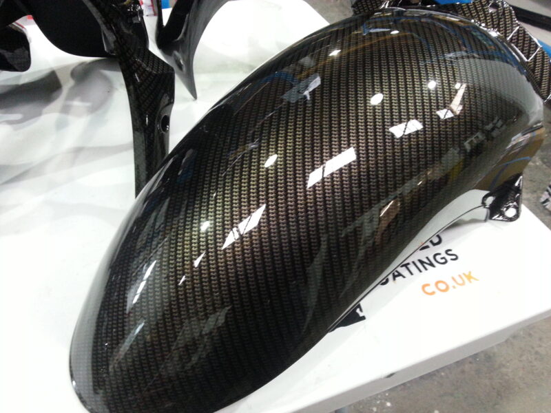 Motorbike parts coated in carbon fibre hydrographic film painted black
