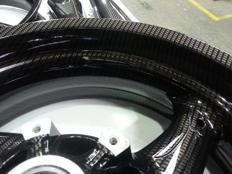 Motorbike parts coated in carbon fibre hydrographic film painted black