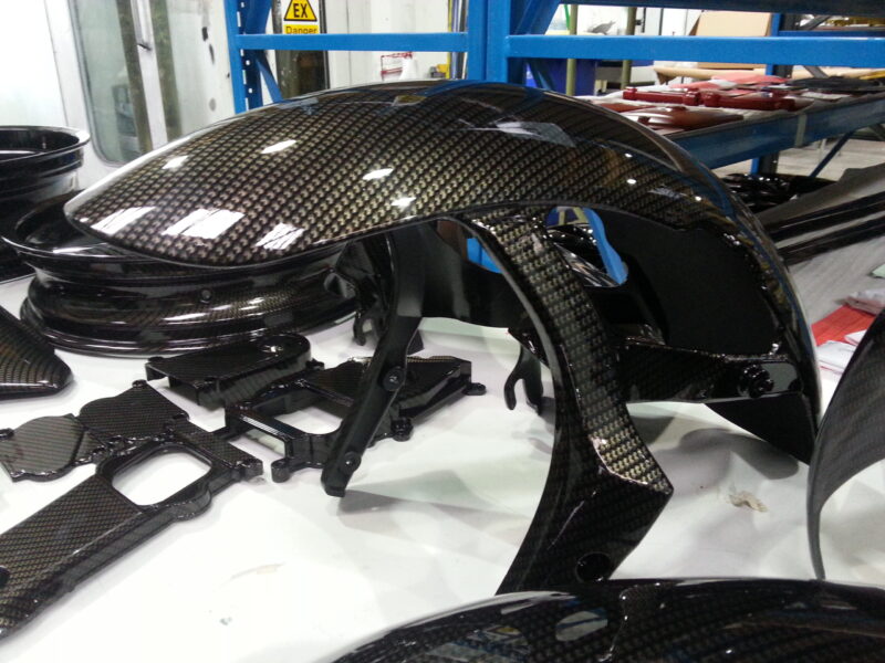 Motorbike parts coated in carbon fibre hydrographic film painted black