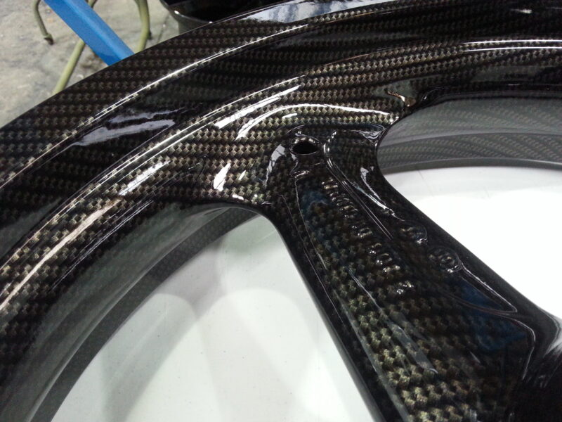Motorbike parts coated in carbon fibre hydrographic film painted black