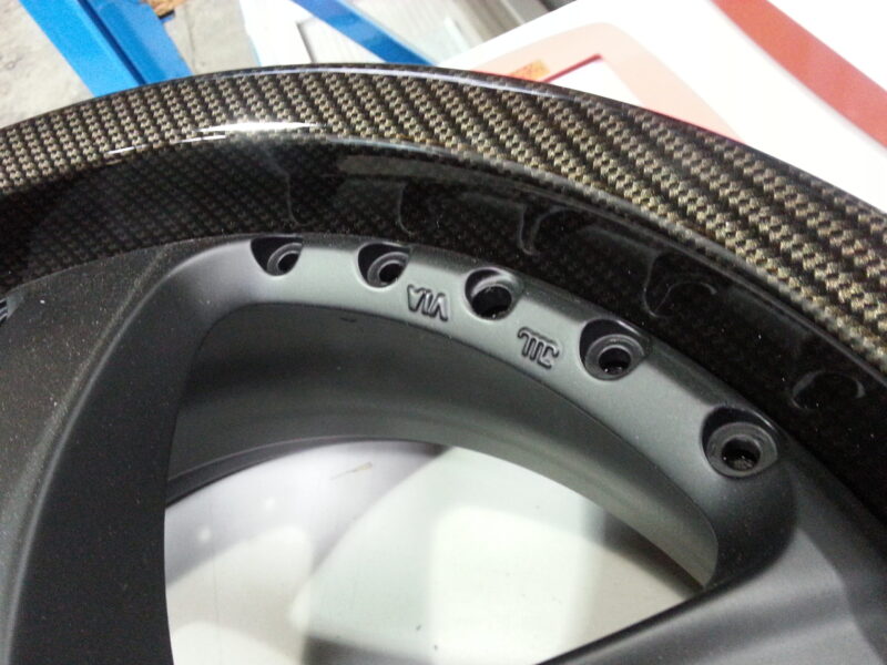 Car alloy wheels coated in carbon fibre hydrographic film painted black