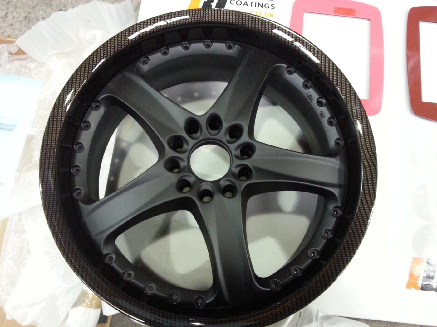 Car alloy wheels coated in carbon fibre hydrographic film painted black