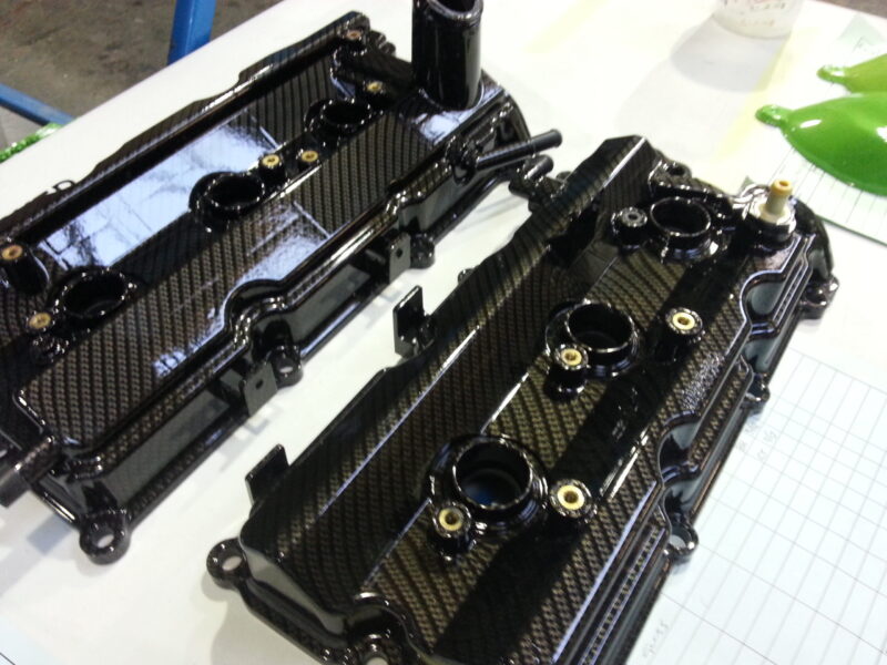 Car engine cover coated in carbon fibre hydrographic film painted black