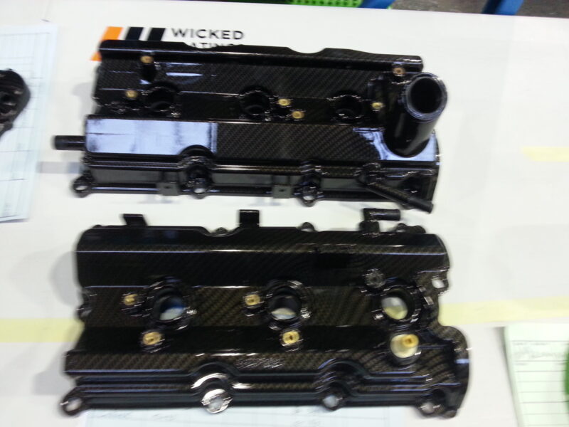 Car engine cover coated in carbon fibre hydrographic film painted black