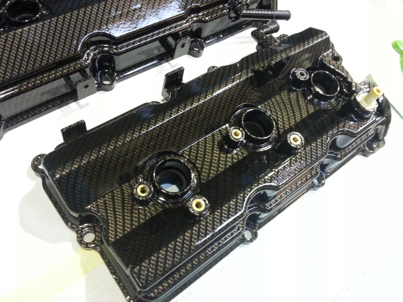 Car engine cover coated in carbon fibre hydrographic film painted black