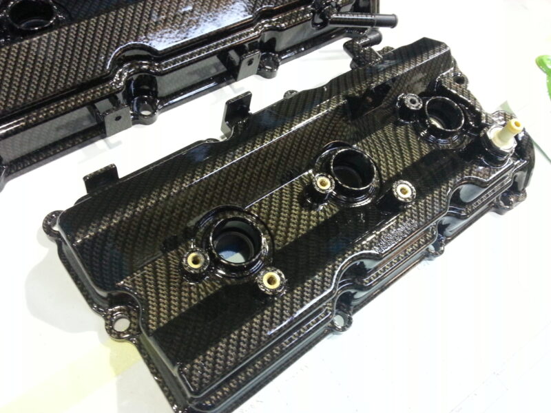 Car engine cover coated in carbon fibre hydrographic film painted black