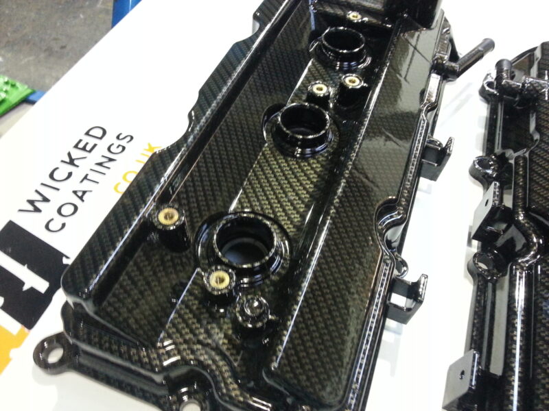Car engine cover coated in carbon fibre hydrographic film painted black