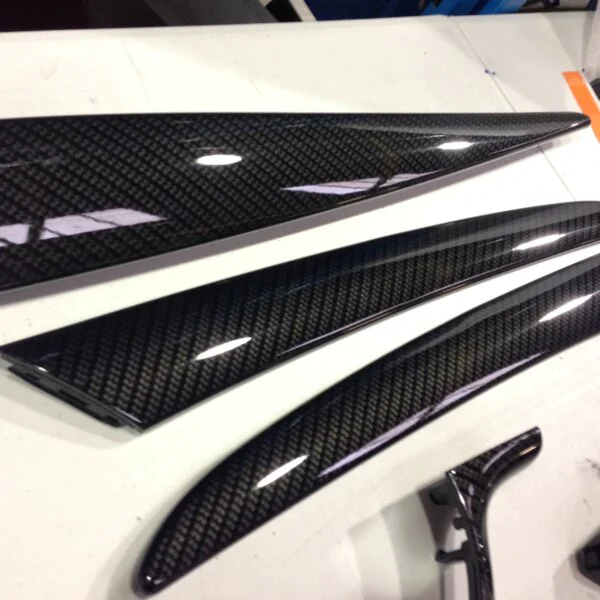 Various car interior parts coated in carbon fibre