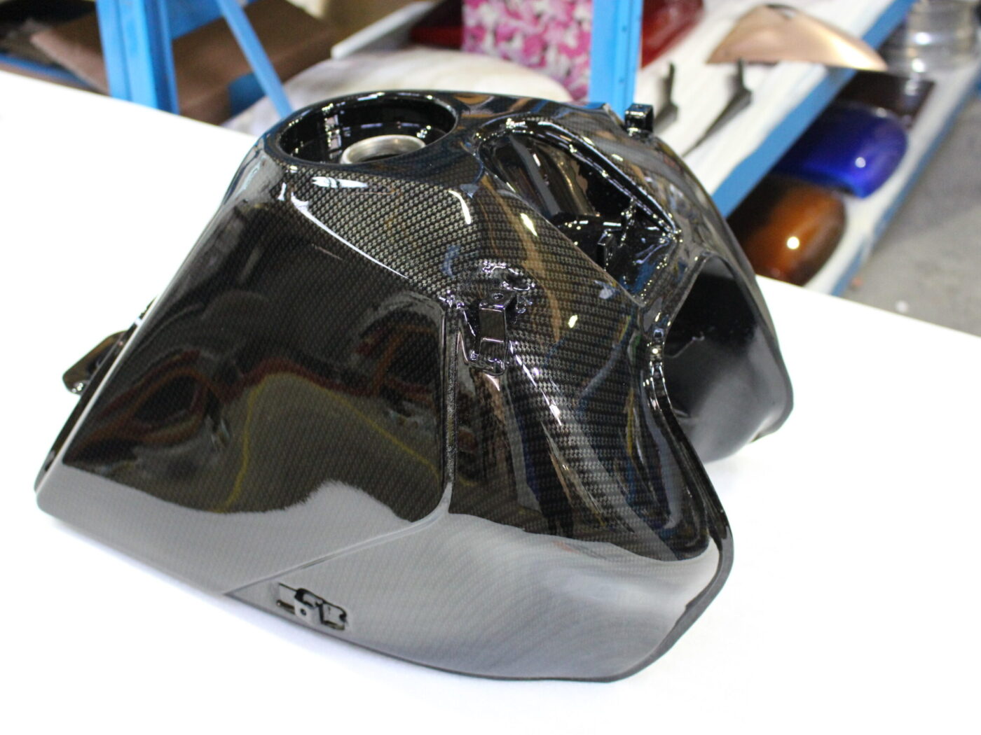 Motorbike tank coated in carbon fibre hydrographic film painted black