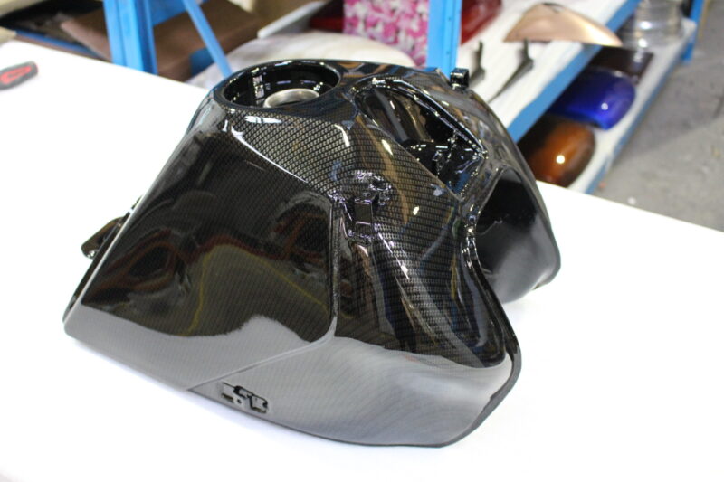 Motorbike tank coated in carbon fibre hydrographic film painted black