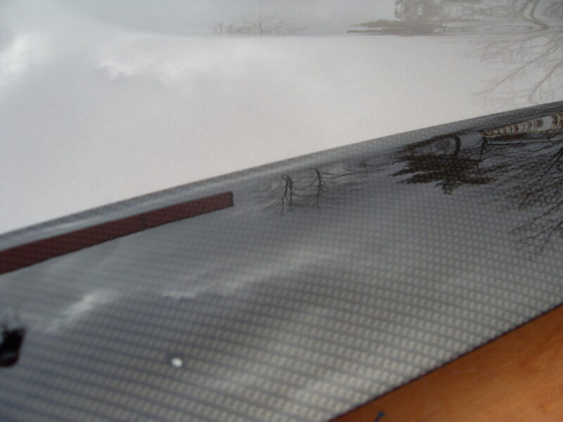 Car hood coated in carbon fibre hydrographic film painted black