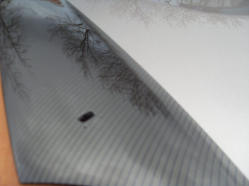 Car hood coated in carbon fibre hydrographic film painted black