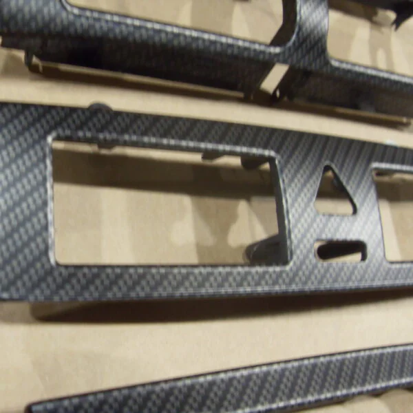Car dashboard elements coated in carbon fibre hydrographic film painted black