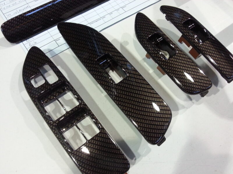 Car dashboard parts coated in carbon fibre hydrographic film painted black