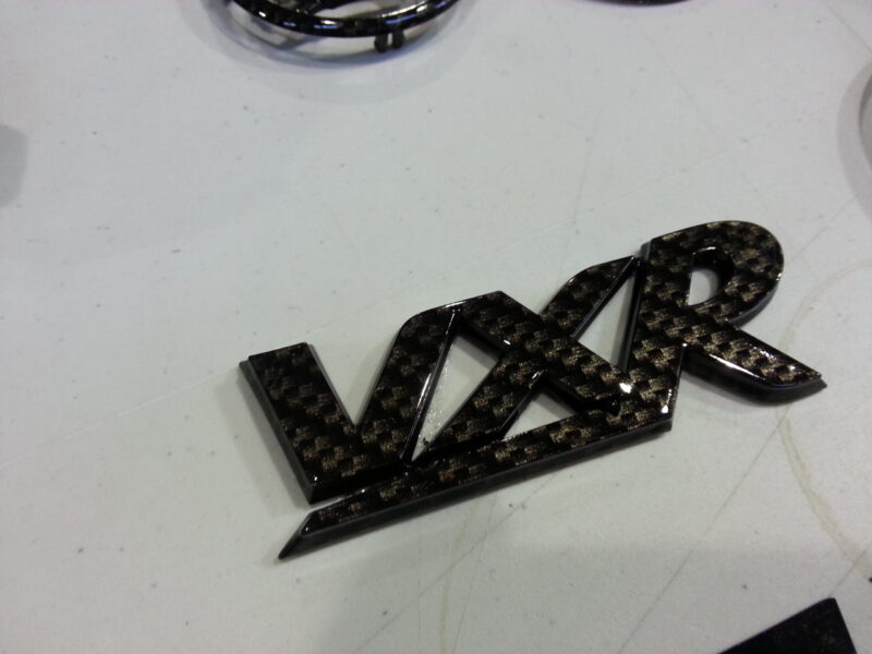 Vauxhall car badge coated in carbon fibre hydrographic film painted black